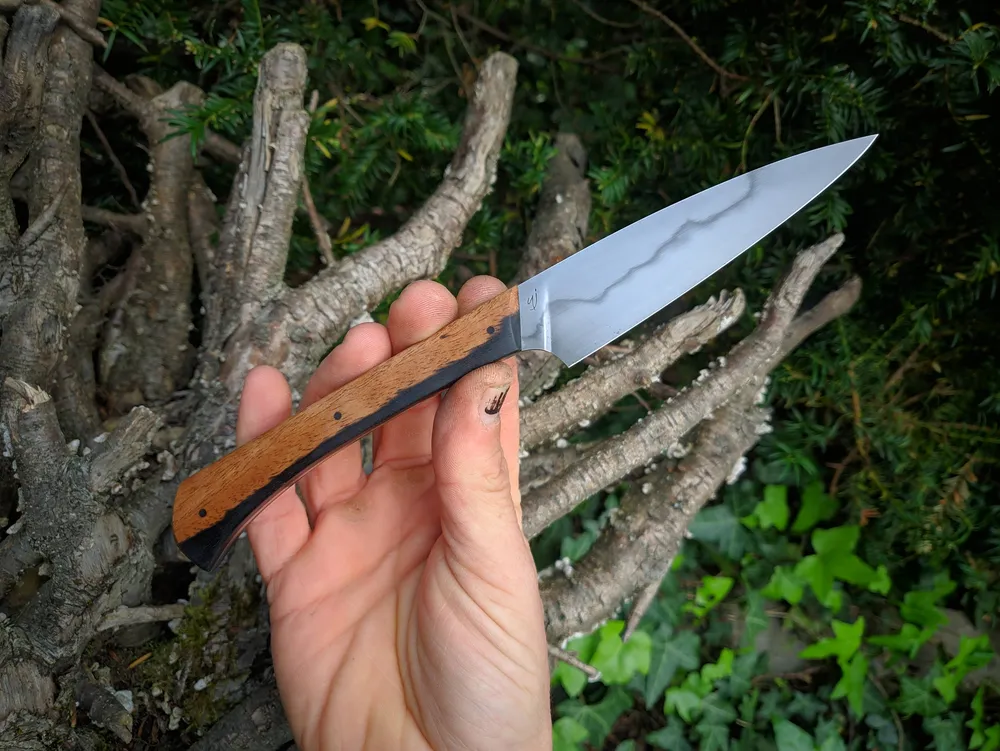 Couteau de table artisanal bicolore en main – Atelier sous l’éclipse
