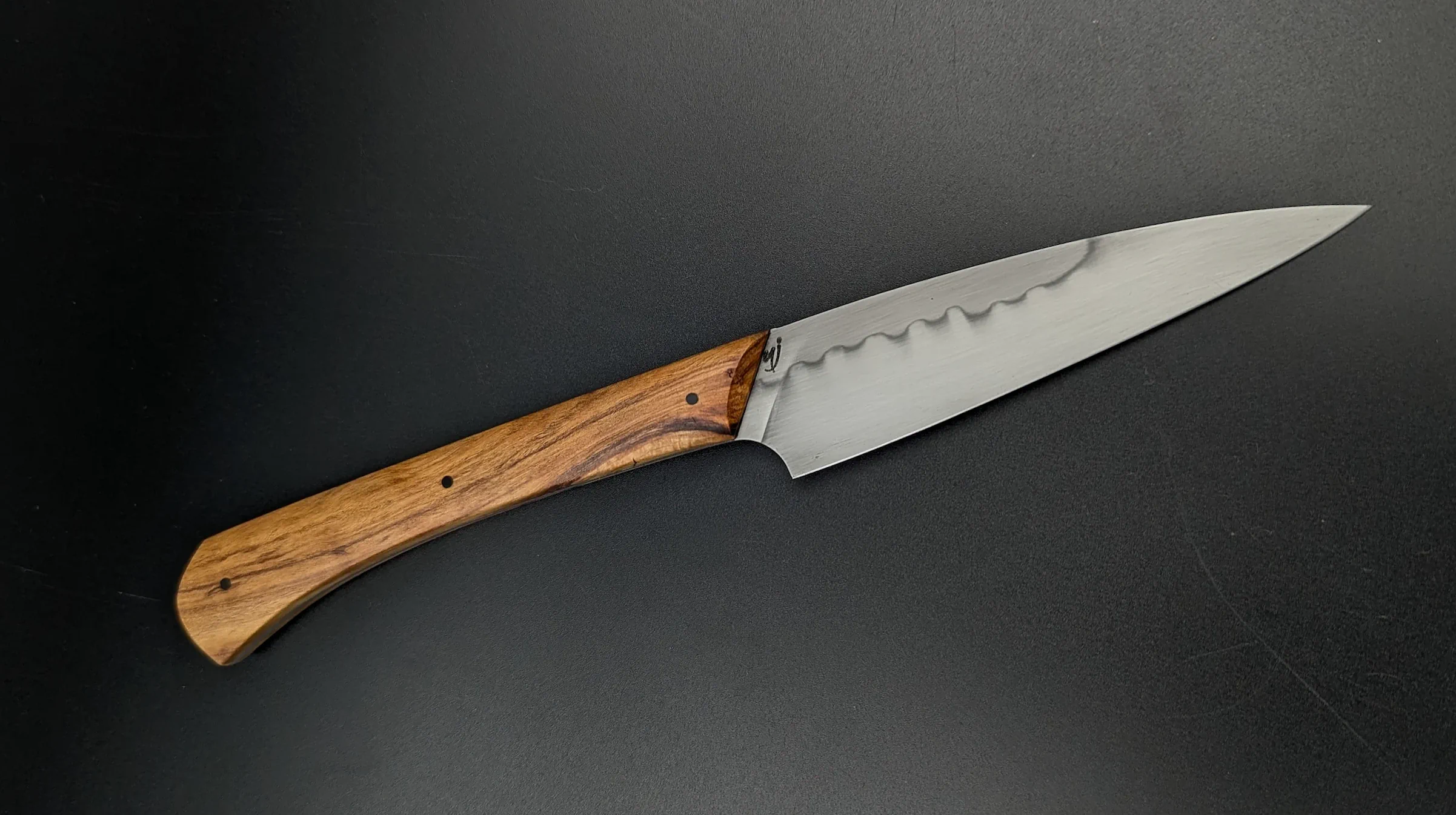 Détail poinçon YJ atelier sous l'éclipse sur lame artisanale